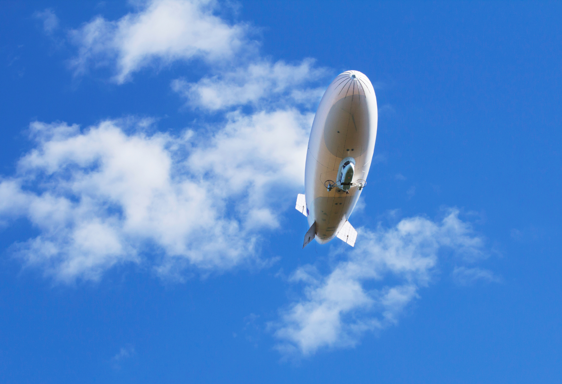 white blimp flying overhead