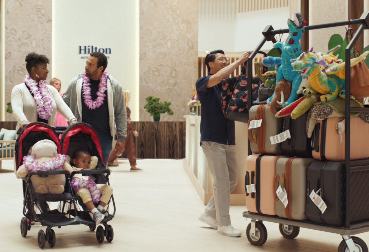 couple walking through a hilton lobby pushing a stroller
