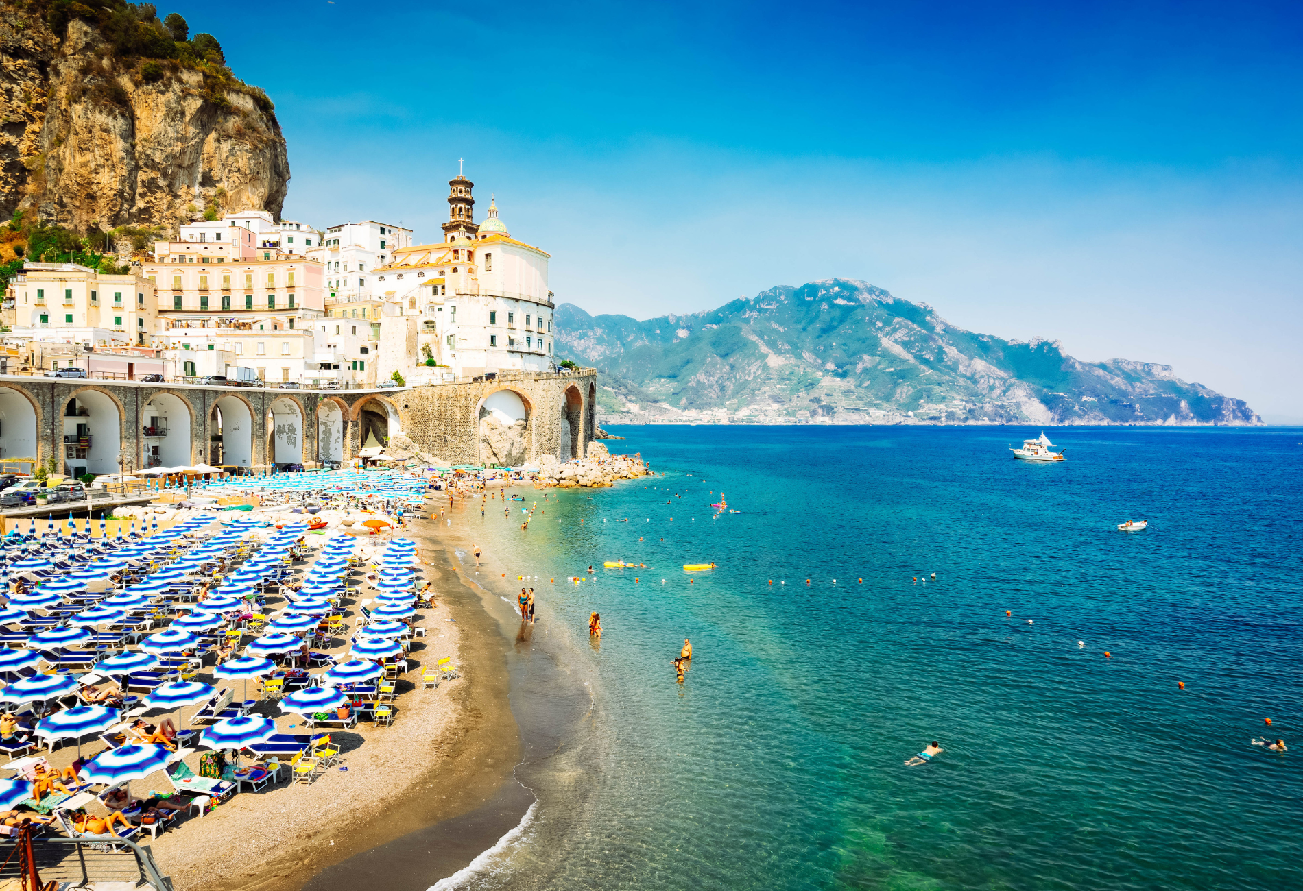 aerial view of an italian beach with sunchairs and people in the water