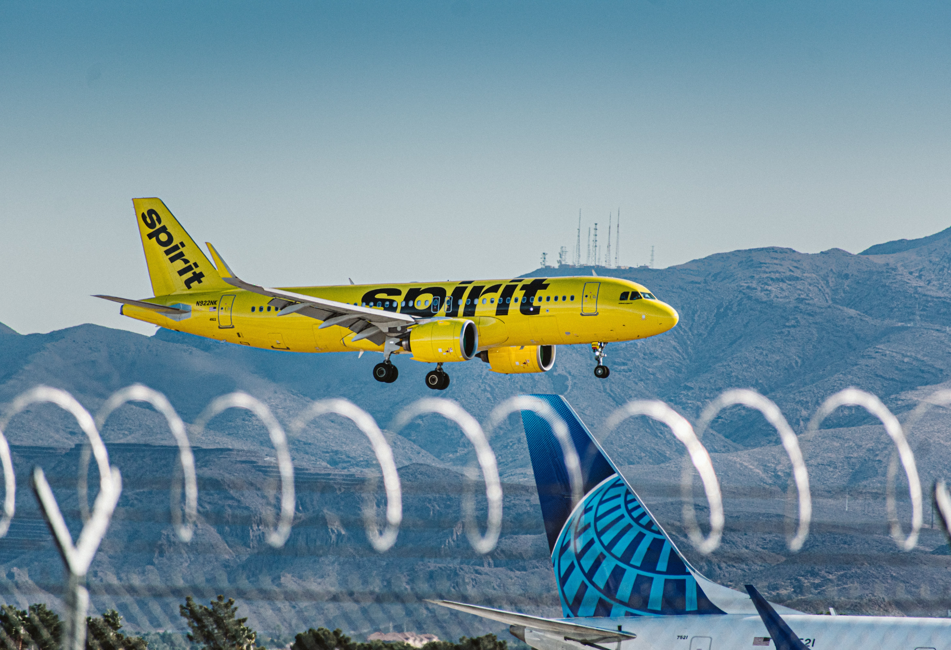 A yellow Spirit Airlines plane landing at an airport