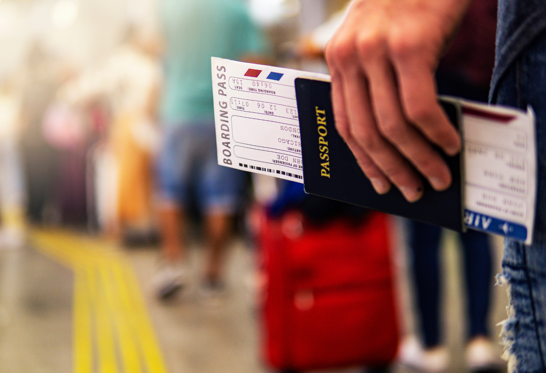 close up of hand holding boarding pass inside a US passport