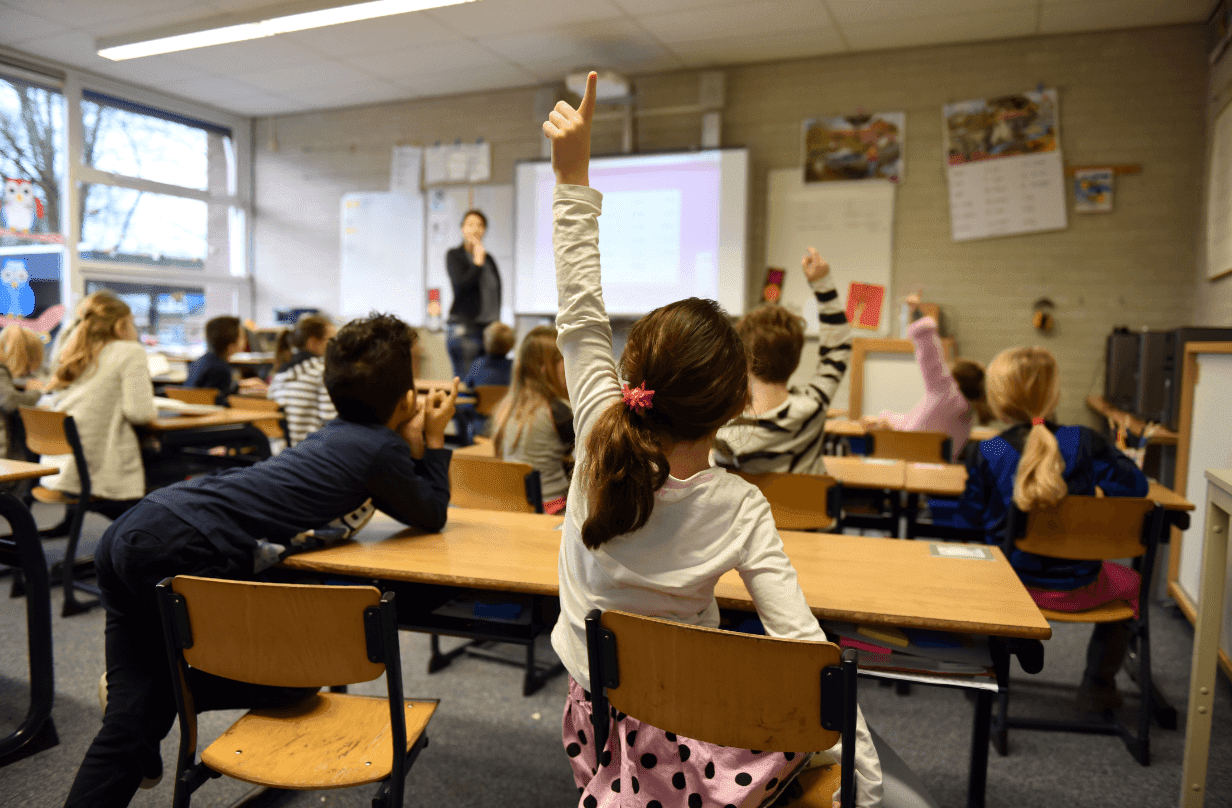 Kid in classroom raising hand