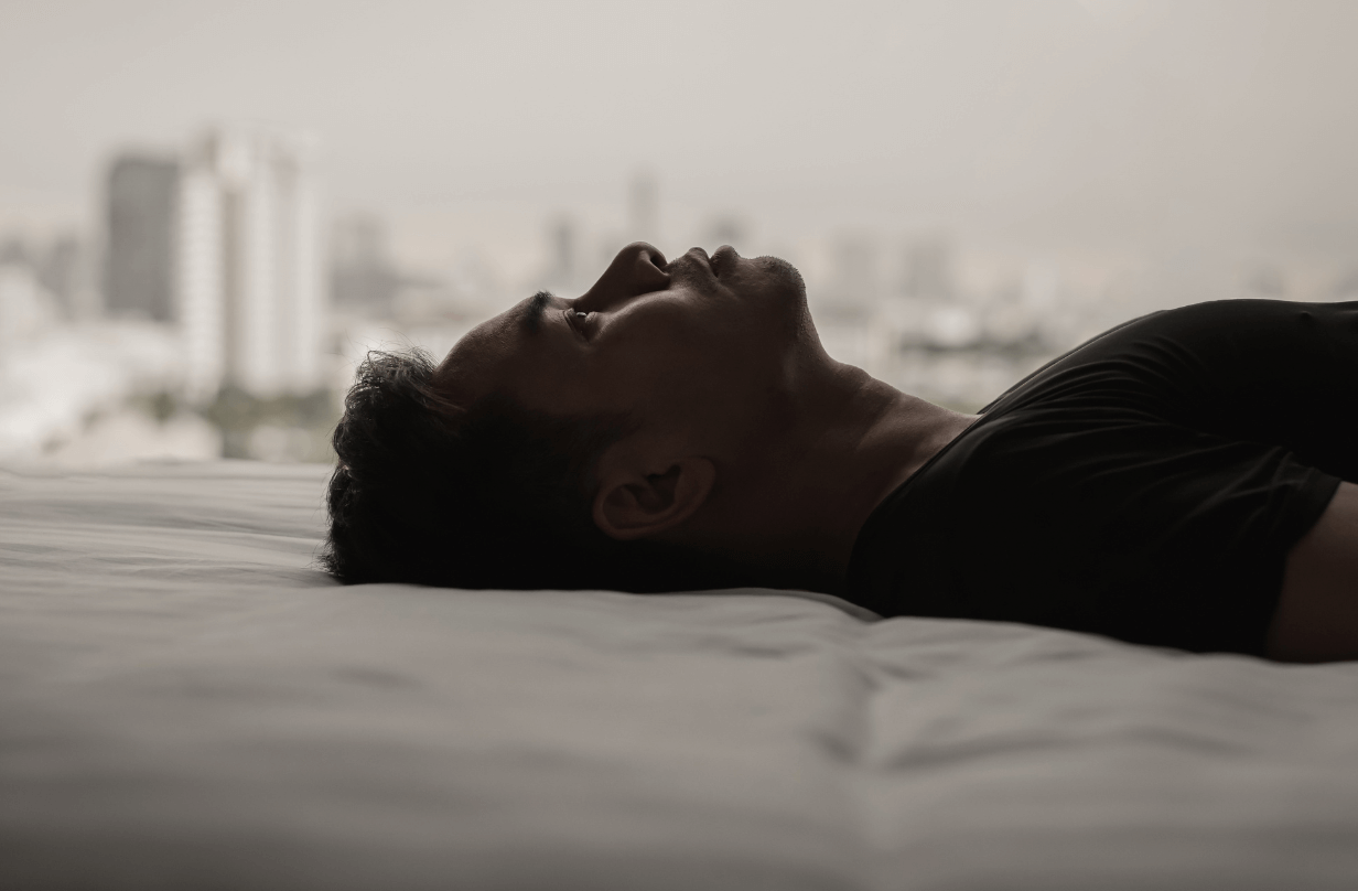 man looking up while laying on bed