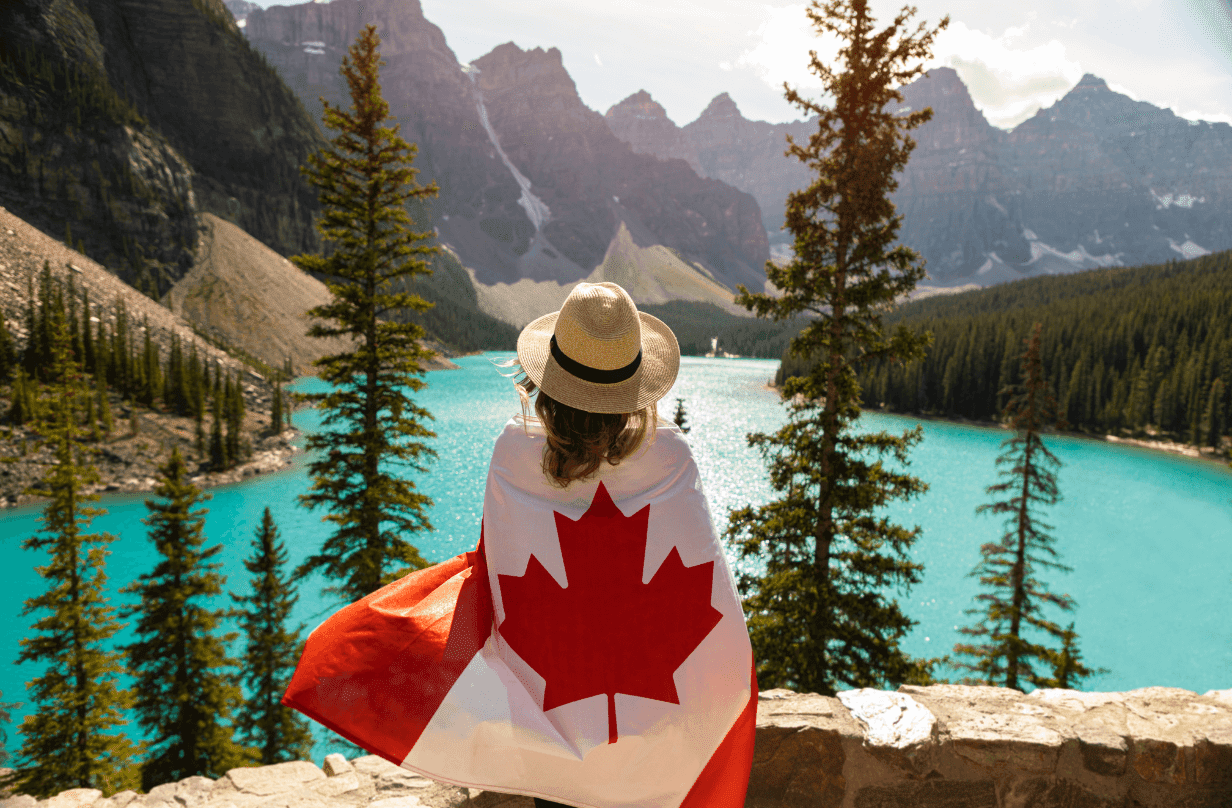 woman looking at water in banff with canadian flag