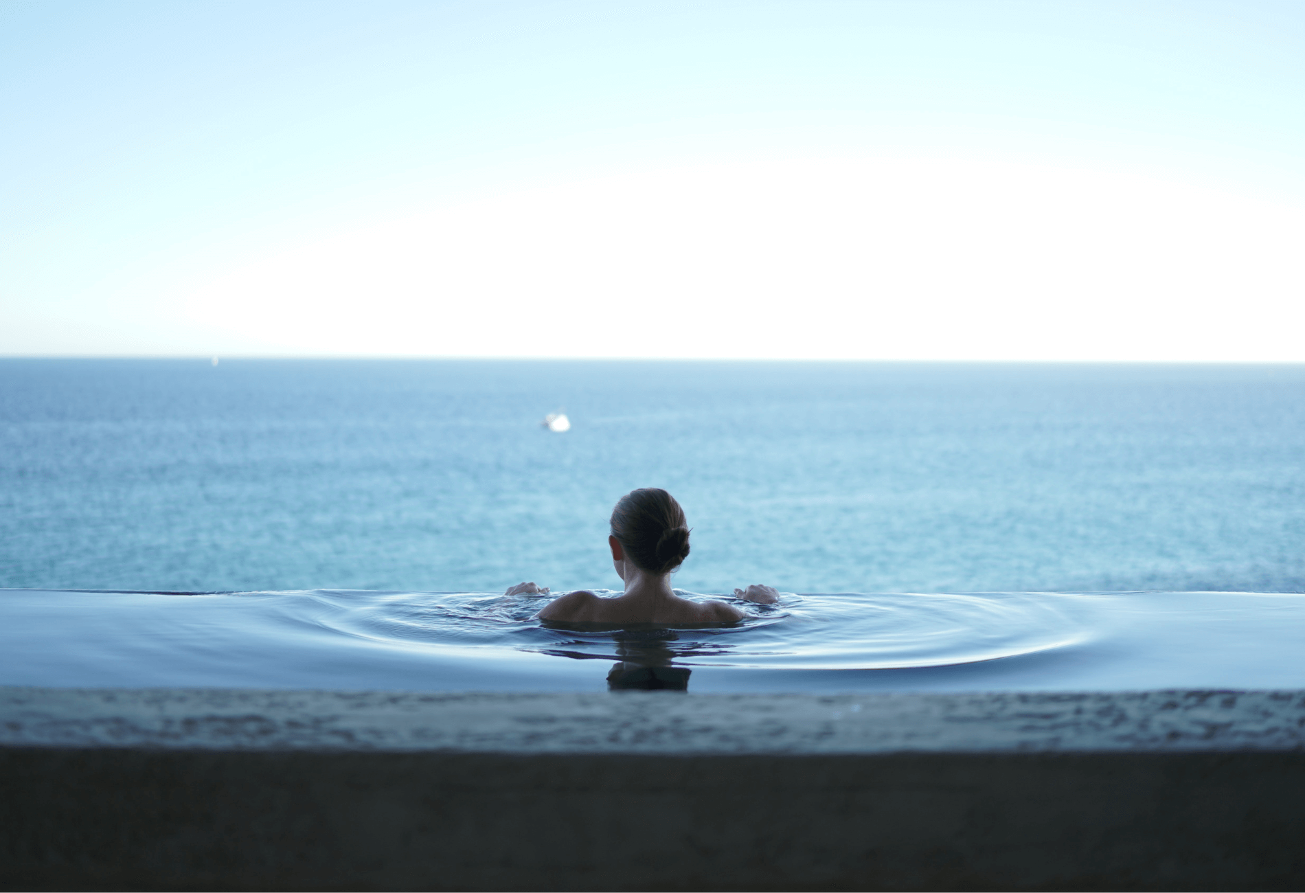 woman relaxing in spa tub with water view
