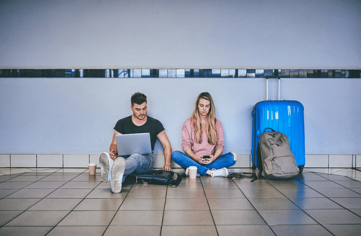 travelers sitting on floor with luggage