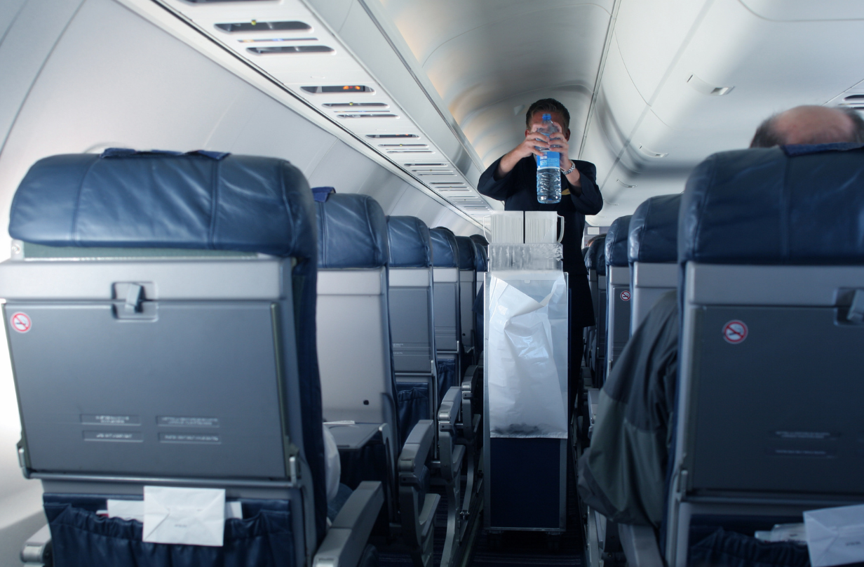 flight attendant between aisles on plane