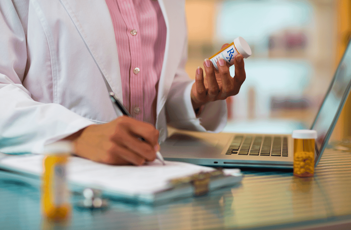 pharmacist looking at orange Rx prescription bottle