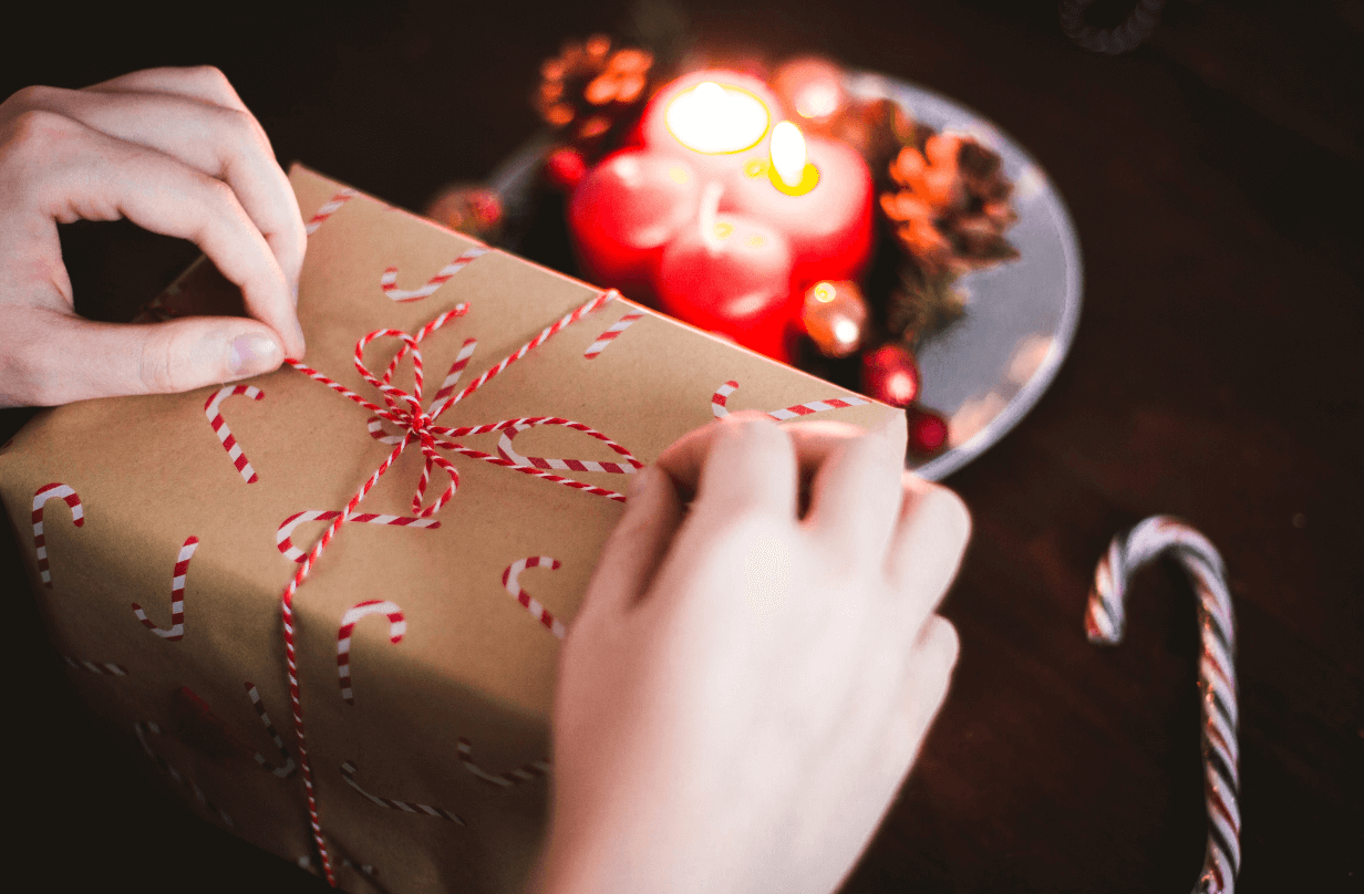 person wrapping gift with string