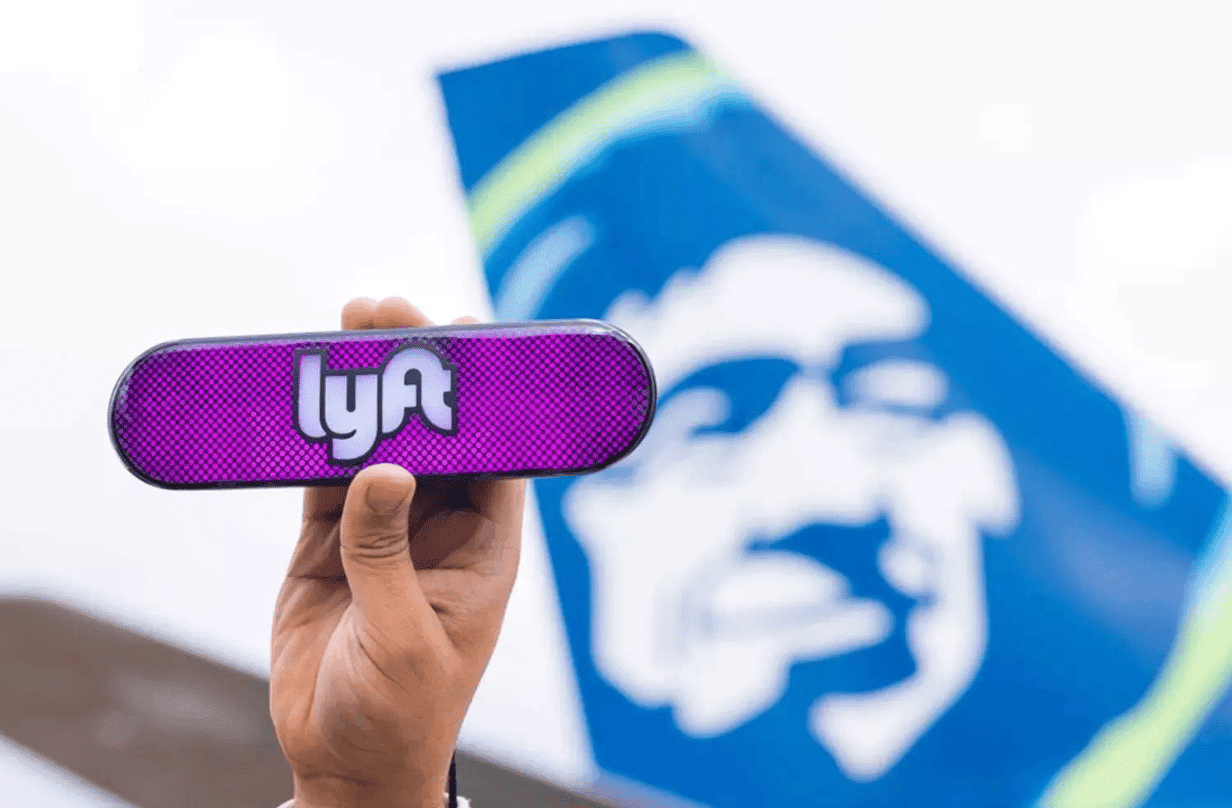 person holding lyft logo with alaska airlines logo in background