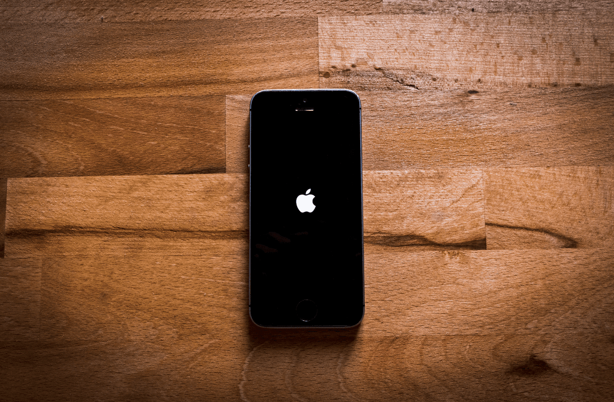 apple logo on phone on wood background