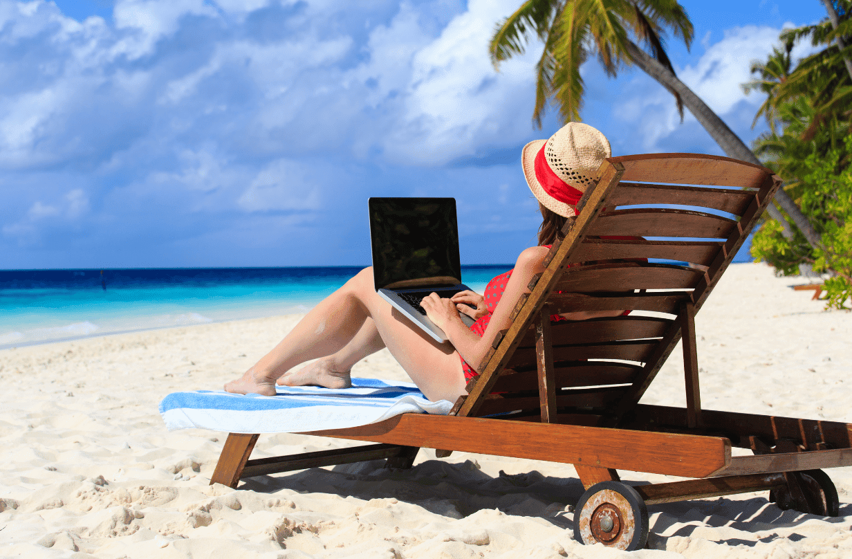 woman laying in beach chair with laptop