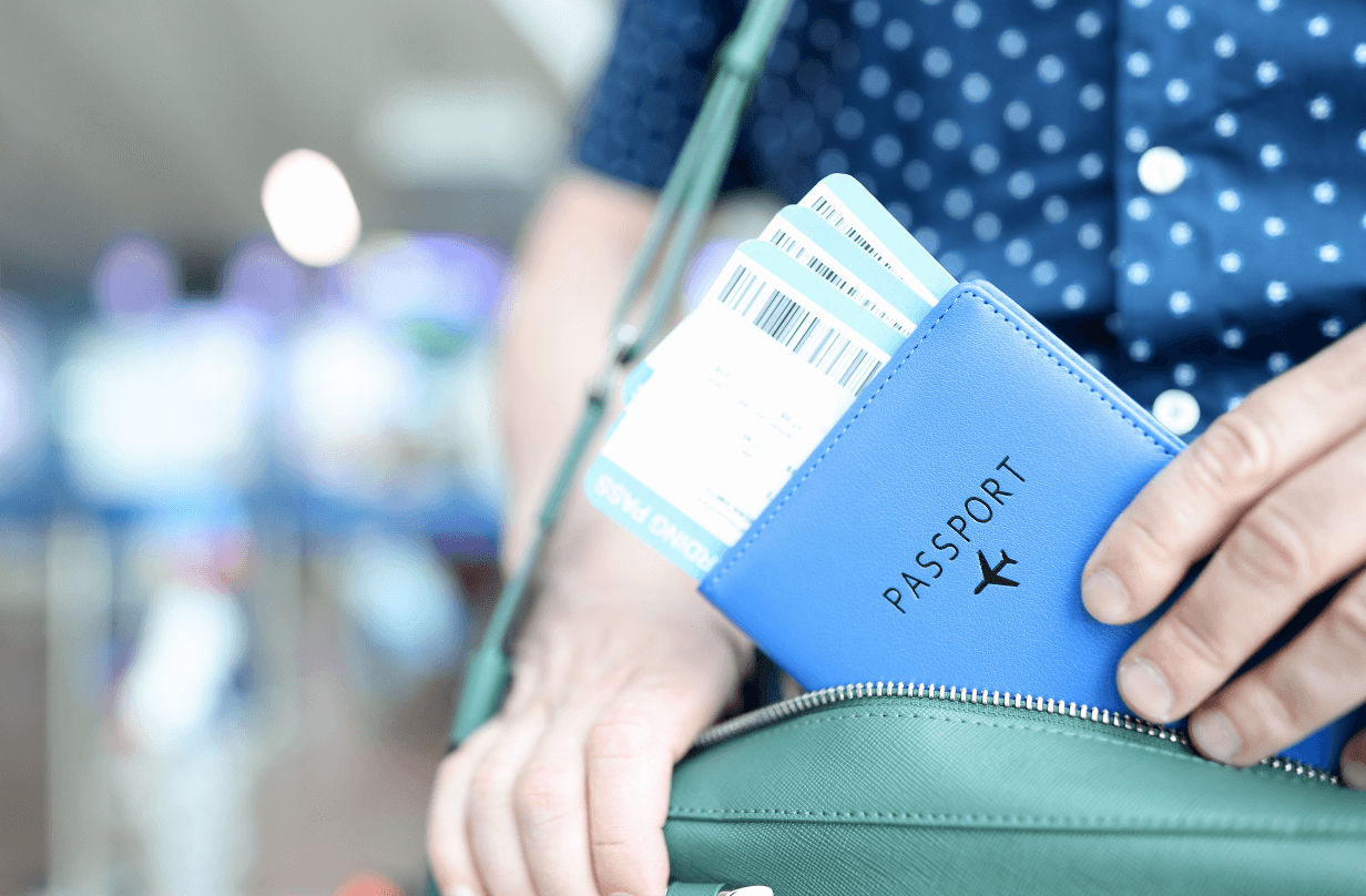 man holding passport and plane tickets