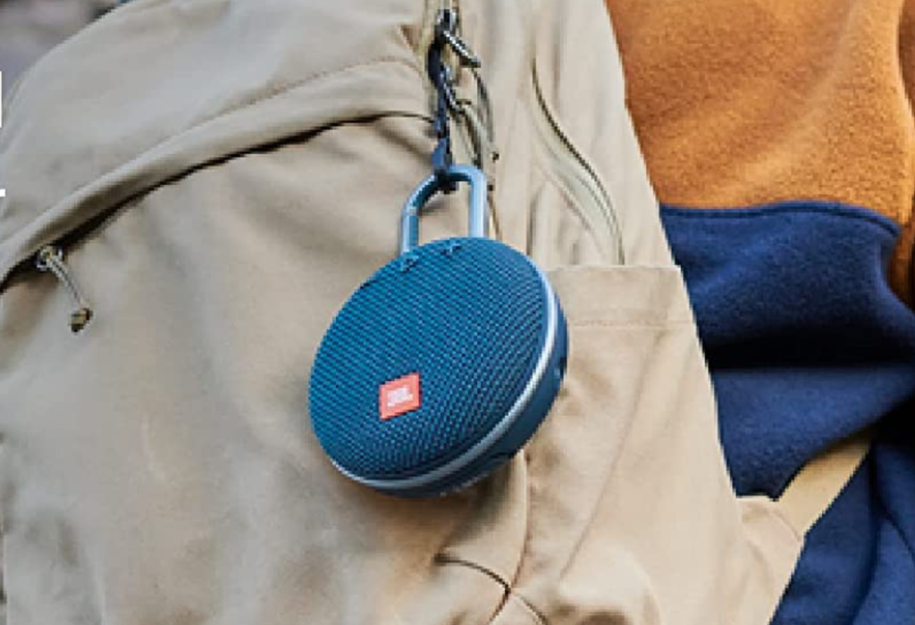 blue JBL portable speaker hanging on backpack with carabiner 