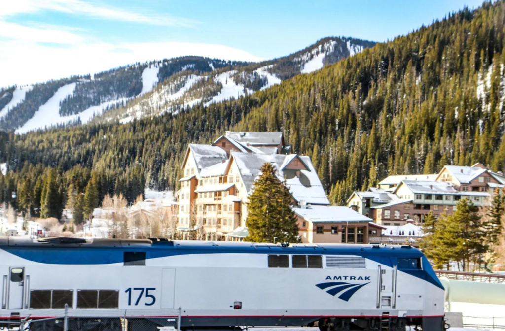 amtrak train with snowy mountain in background