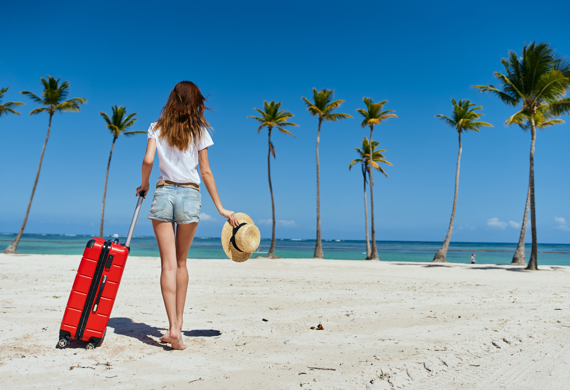 woman with suitcase on a beach