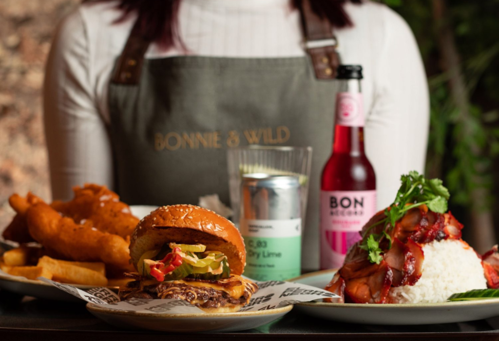 burger and other food items on a tray held by a server