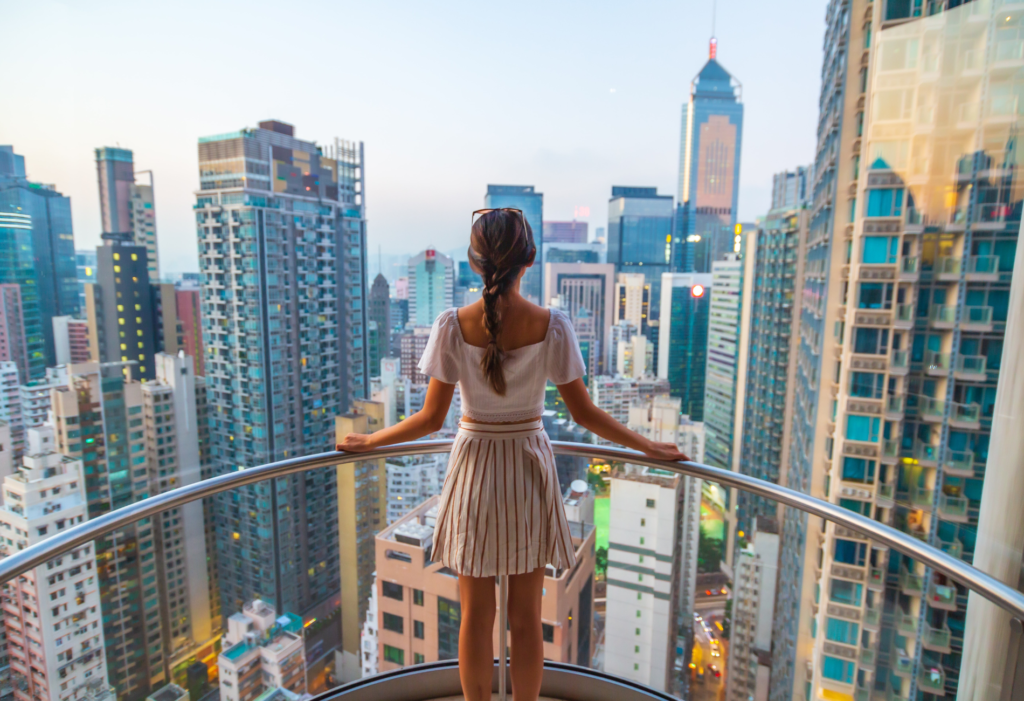 Woman staring out from balcony in Hong Kong