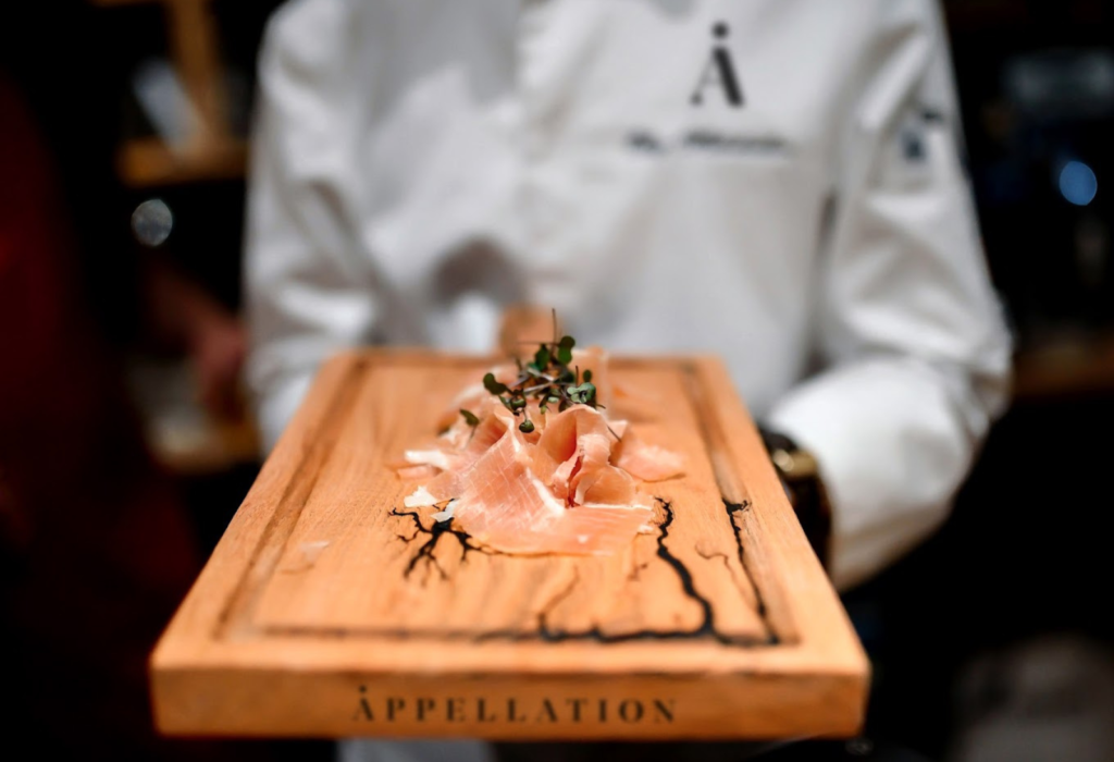 cutting board with meat on it being held by a server