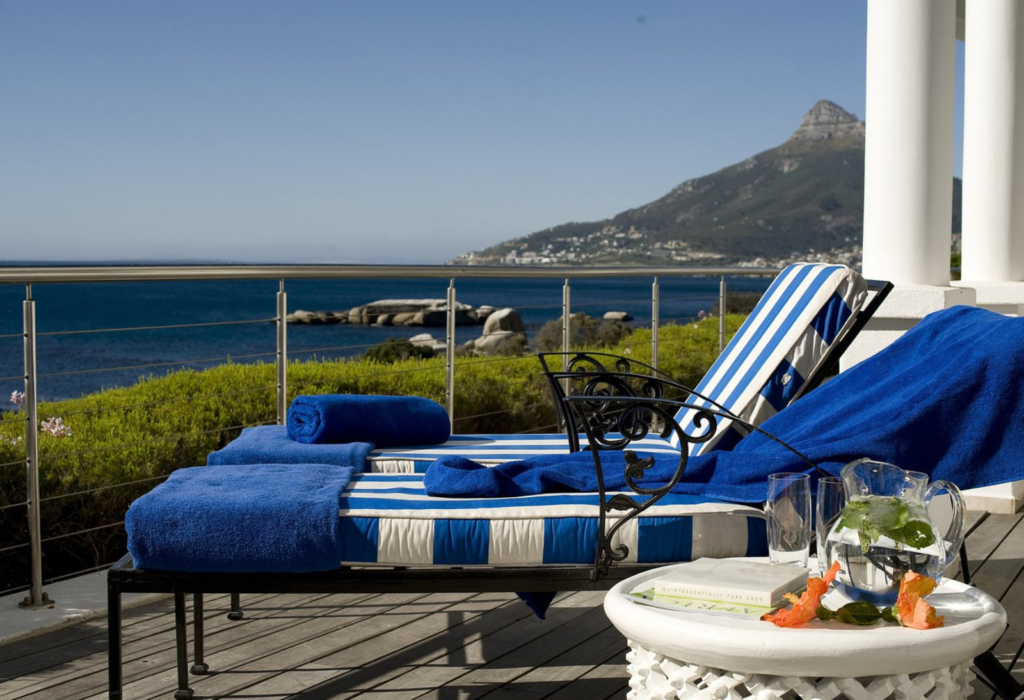 two blue lounge chairs on patio overlooking the ocean