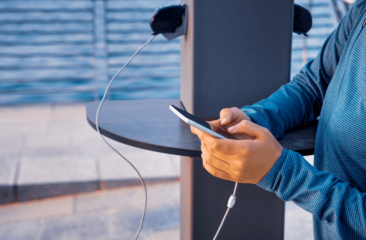 person charging phone at charging stations