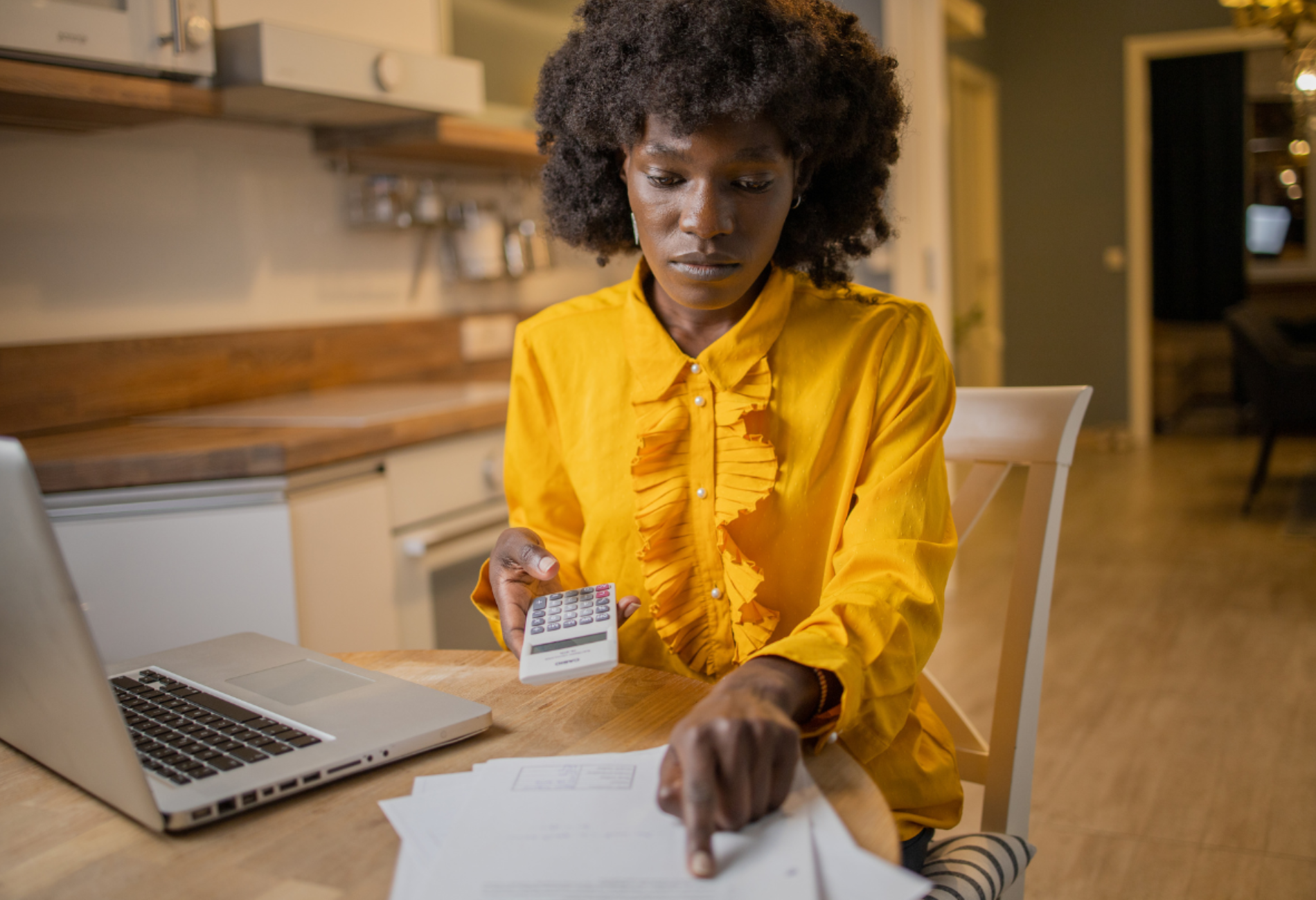 woman in yellow shirt doing her taxes for story on Kayak's tax refund calculator