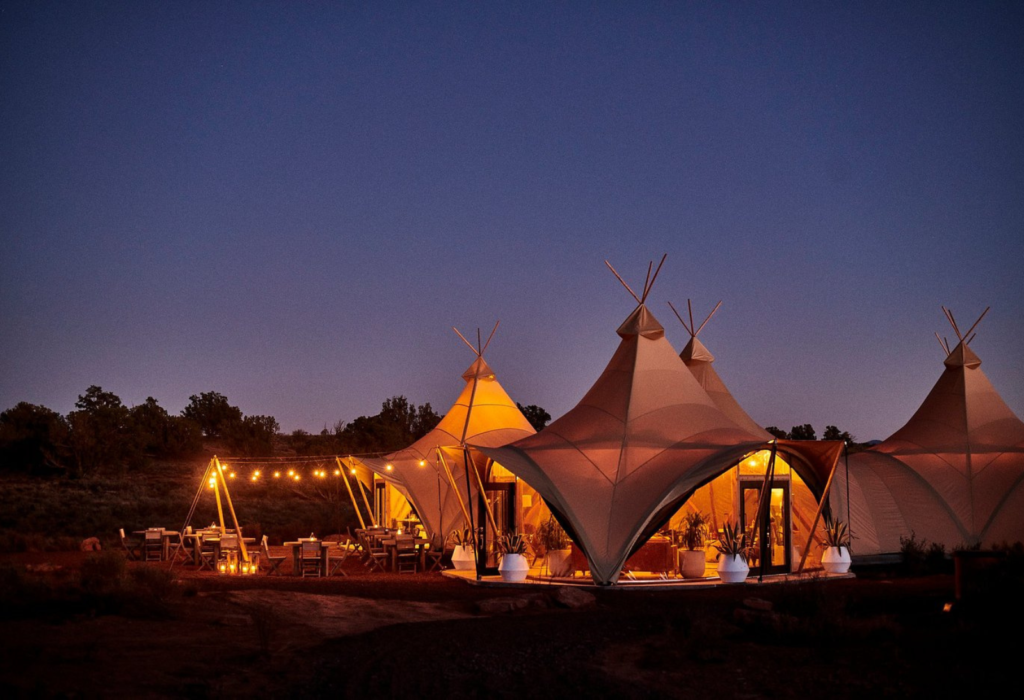 luxury glamping tents lit up at night
