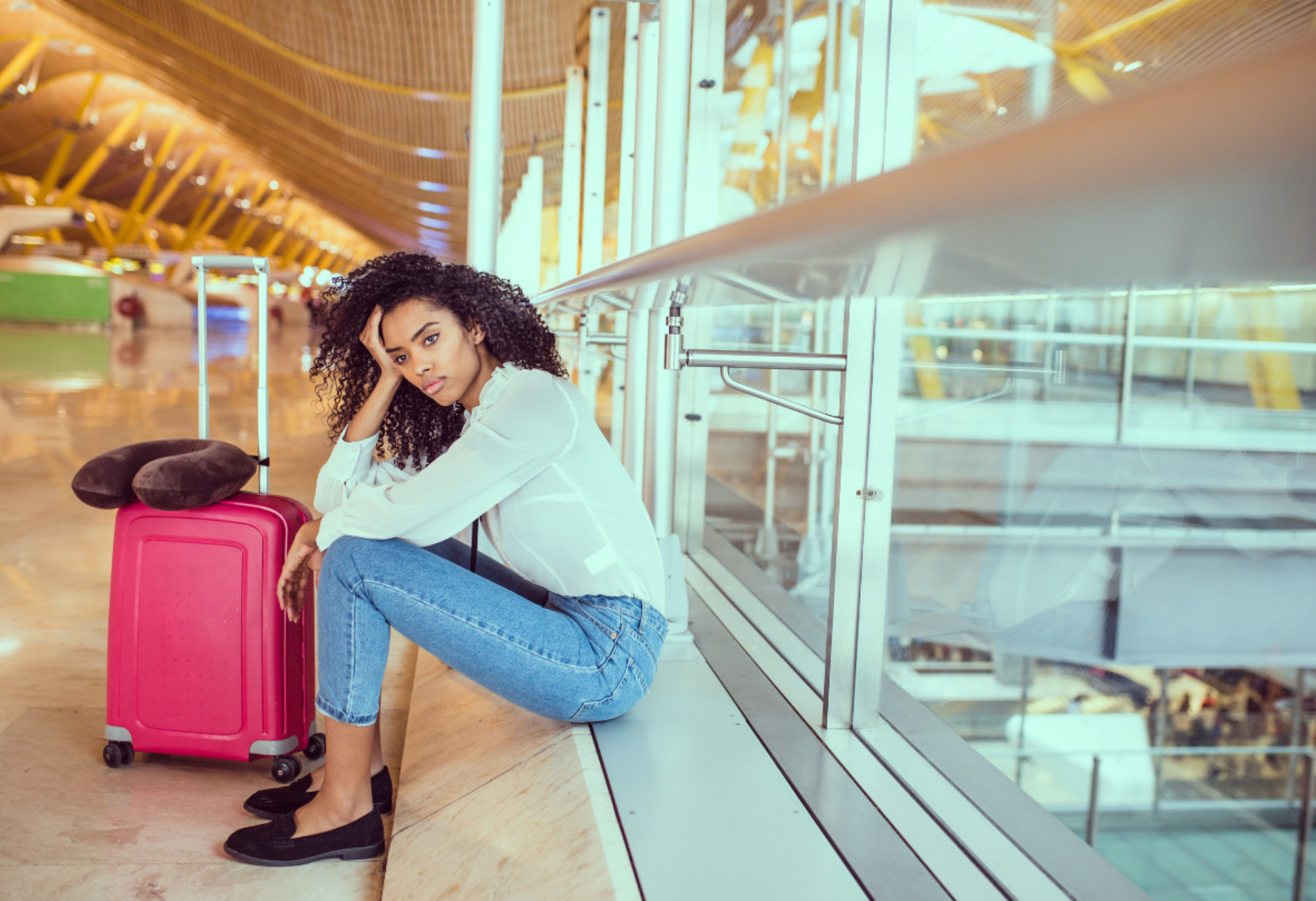 woman at airport with pink luggage