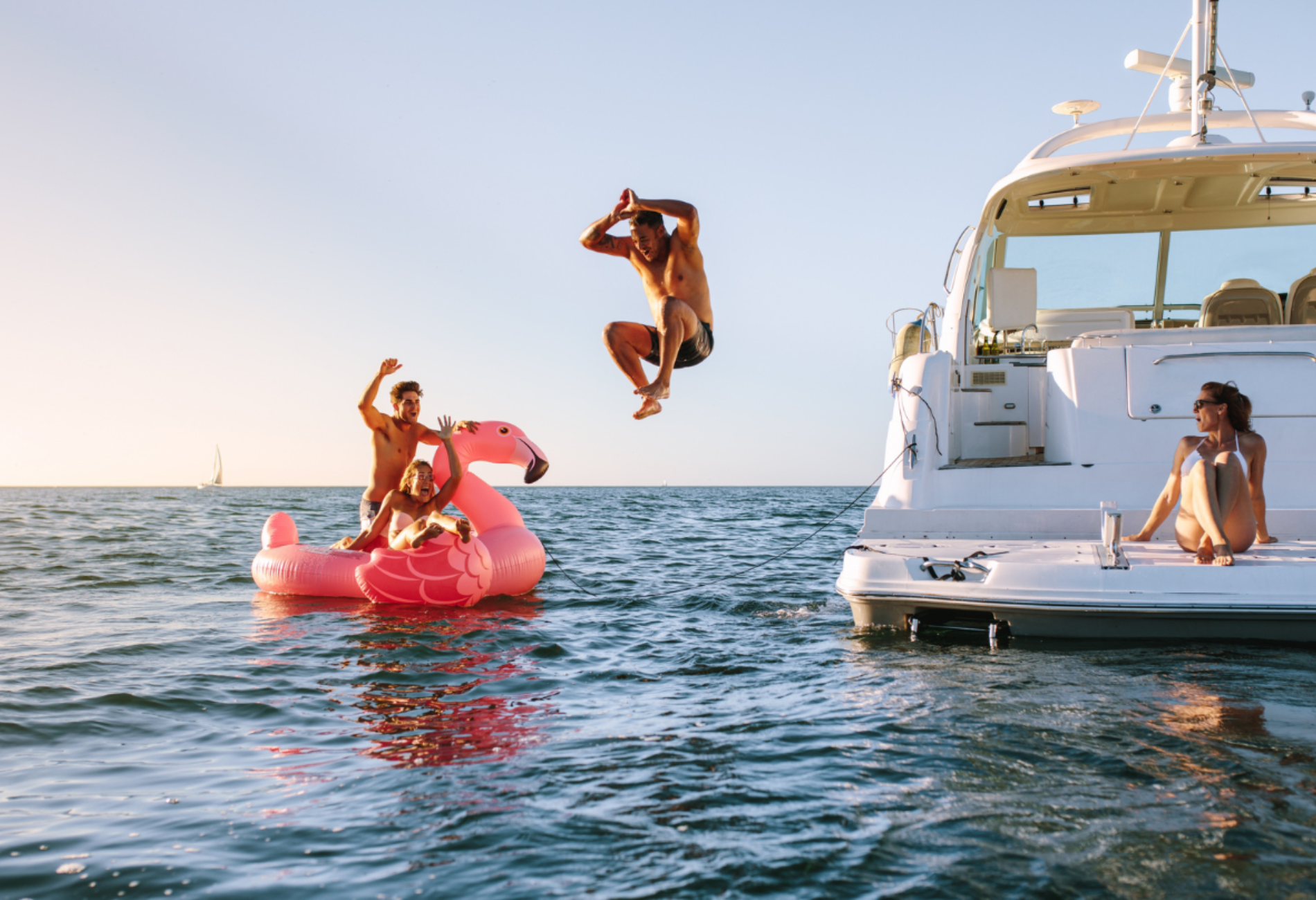 people jumping off a yacht