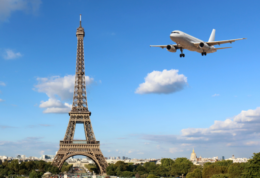 eiffel tower with plane flying over it