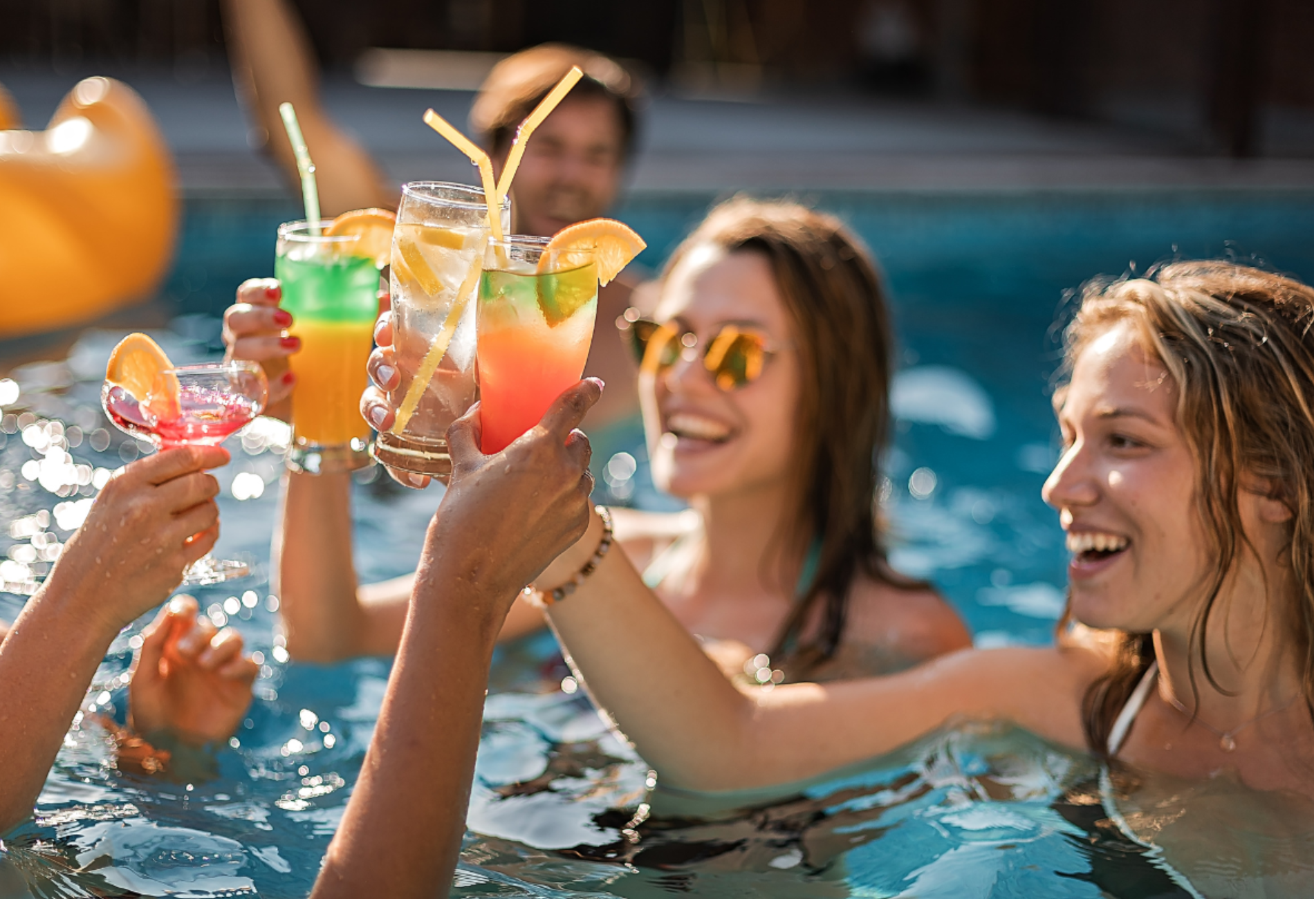 group of young women with cocktails in a pool