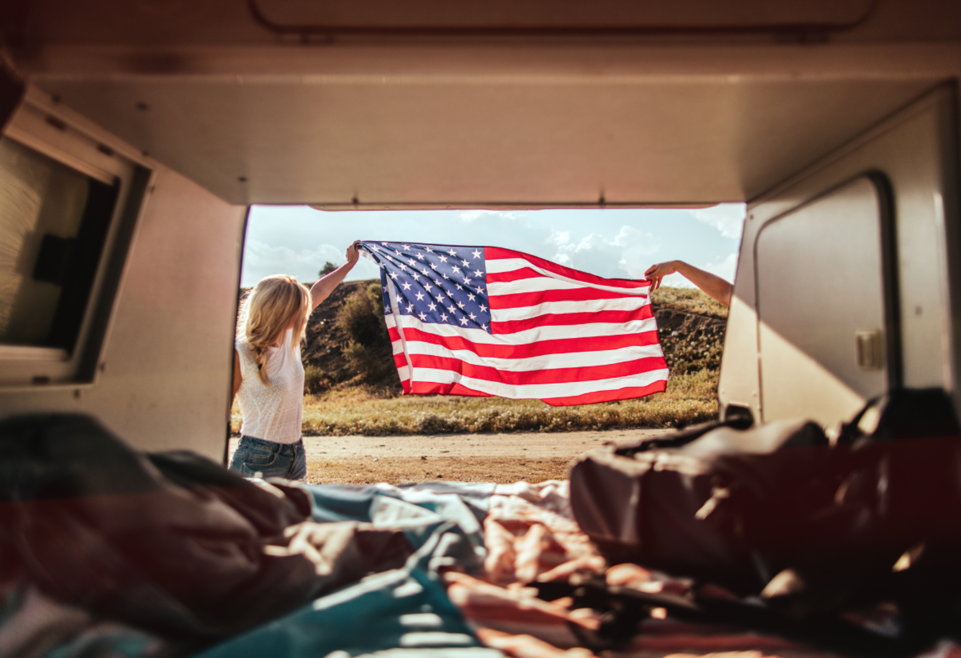 American flag held outside of a van