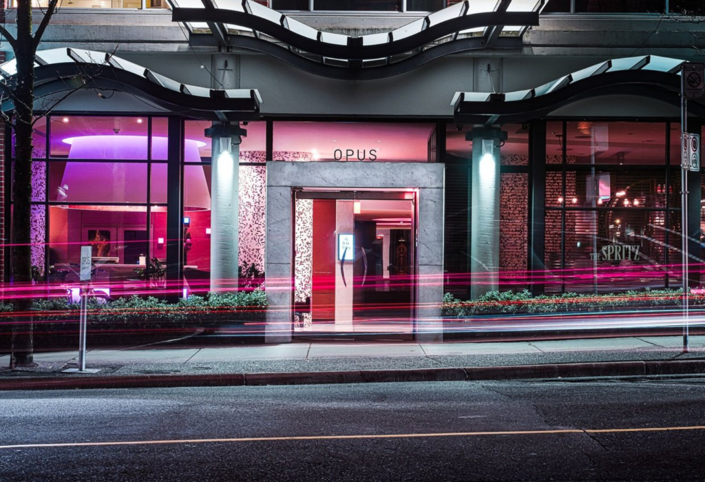 exterior of modenr hotel with purple and pink lighting and curved architecture