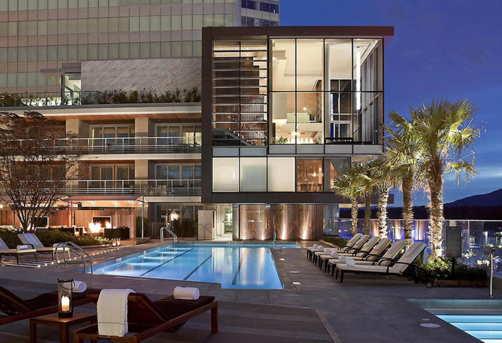 outdoor rooftop view of hotel with swimming pool at night