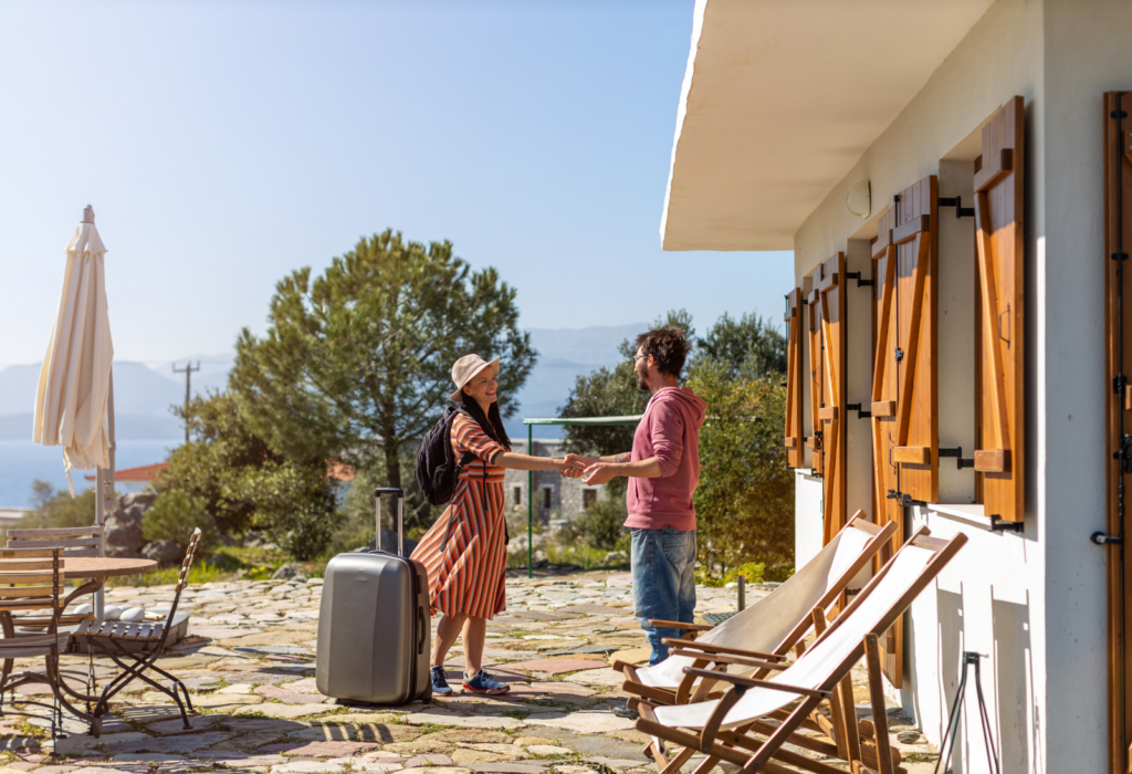 woman shaking hands with man outside home