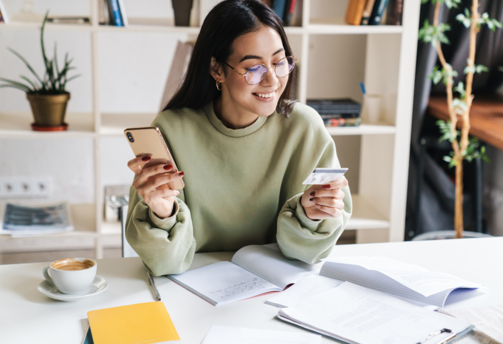 woman holding credit card and iPhone in an office