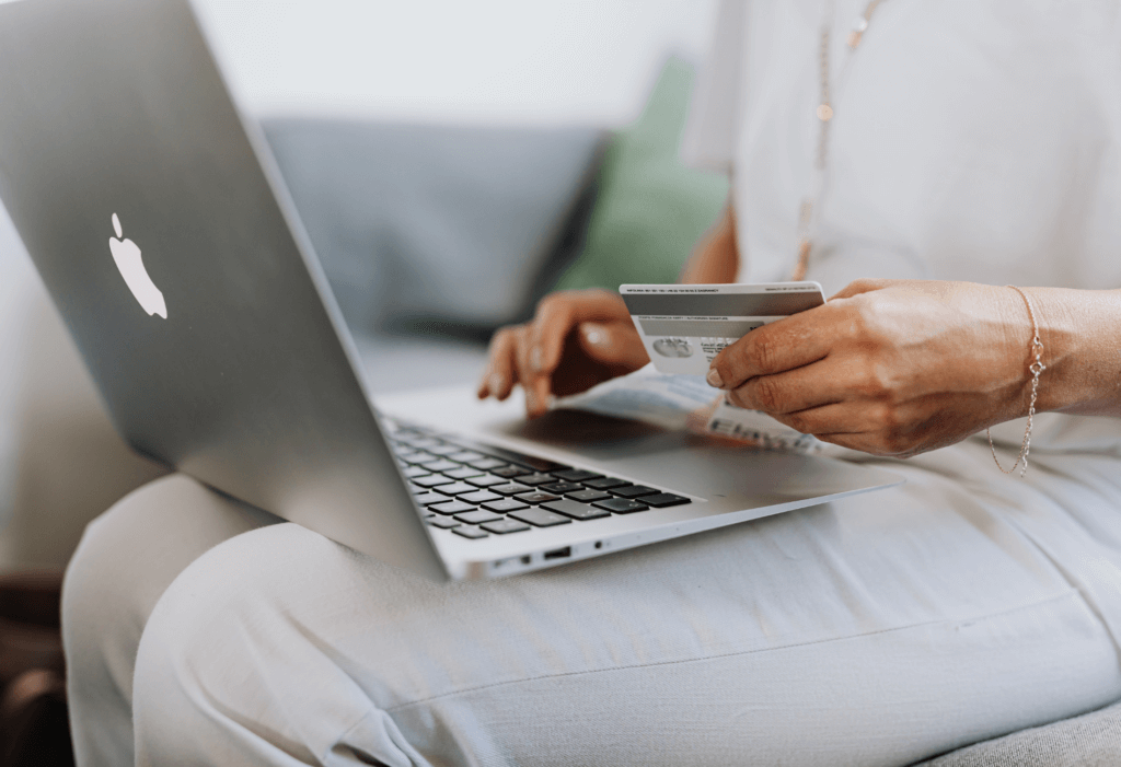 person holding credit card with laptop on them