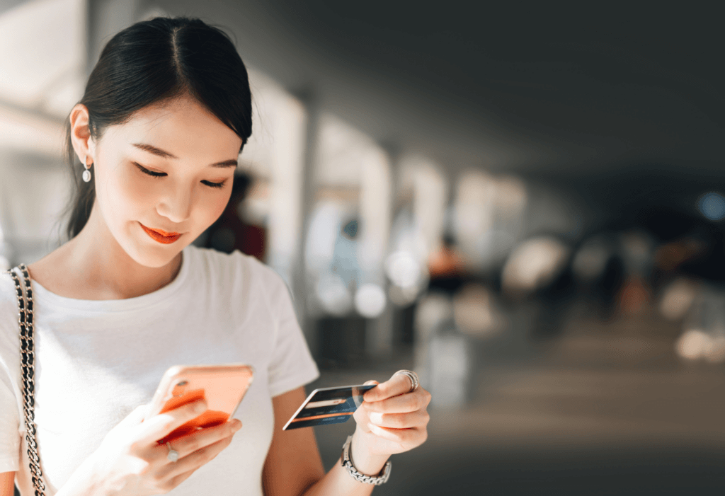 woman holding credit card and phone