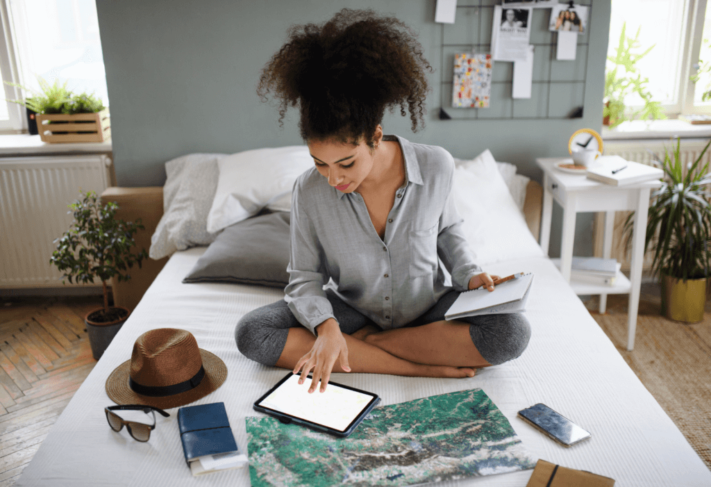 woman sitting on bed on tablet