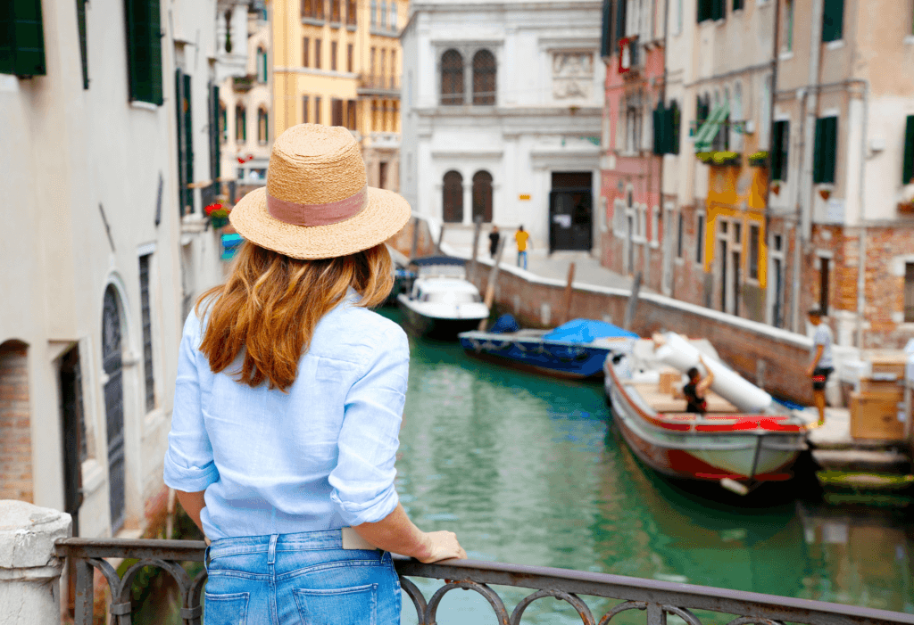 woman with hat looking out over the Venice canals