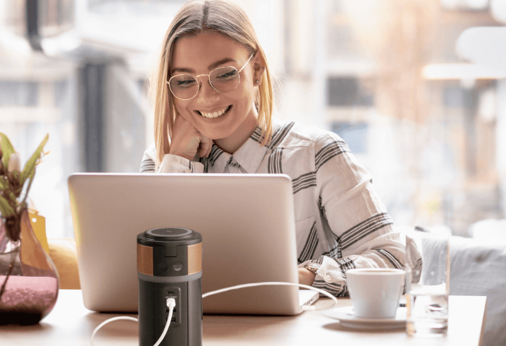 a woman using the duracell m150 portable powerstation to work in a cafe