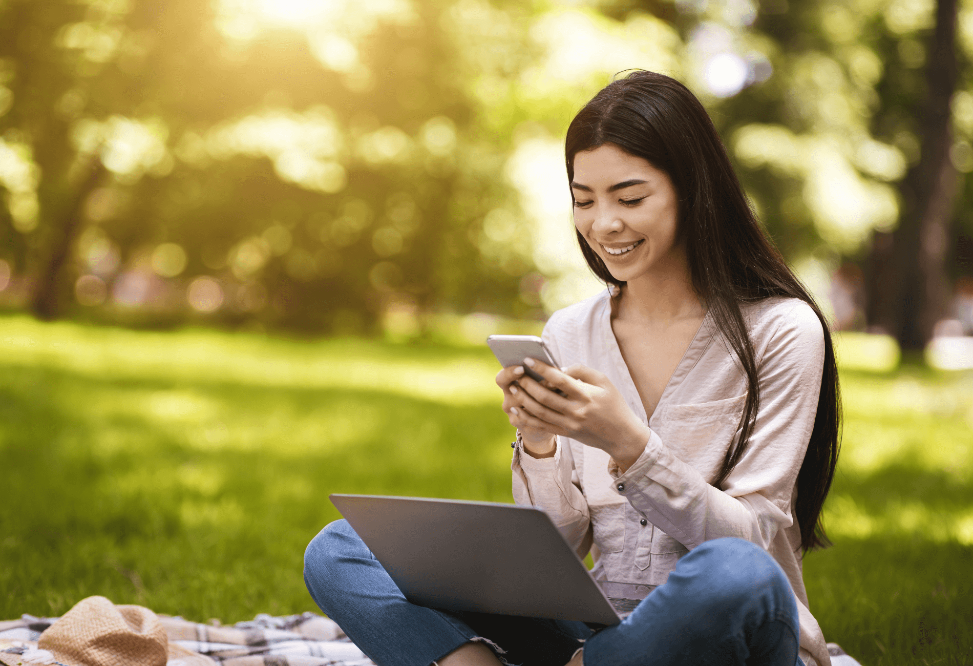 woman on grass outside with laptop