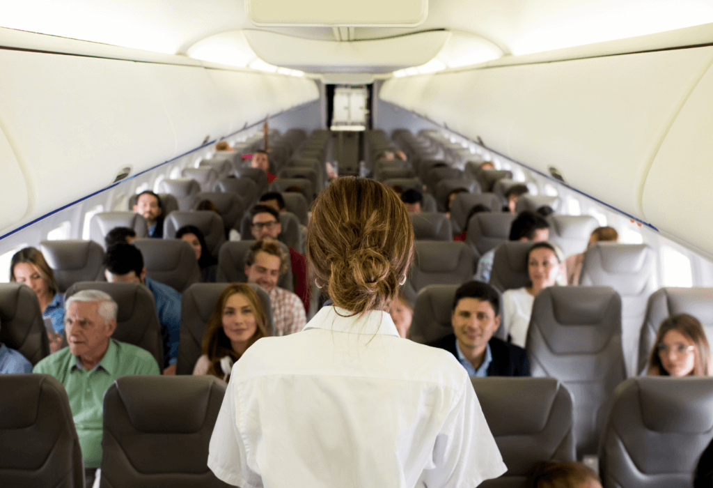 passengers on plane with flight attendant speaking to them for story on cheapest European cities to fly into during the latest Tap Air Portugal sale