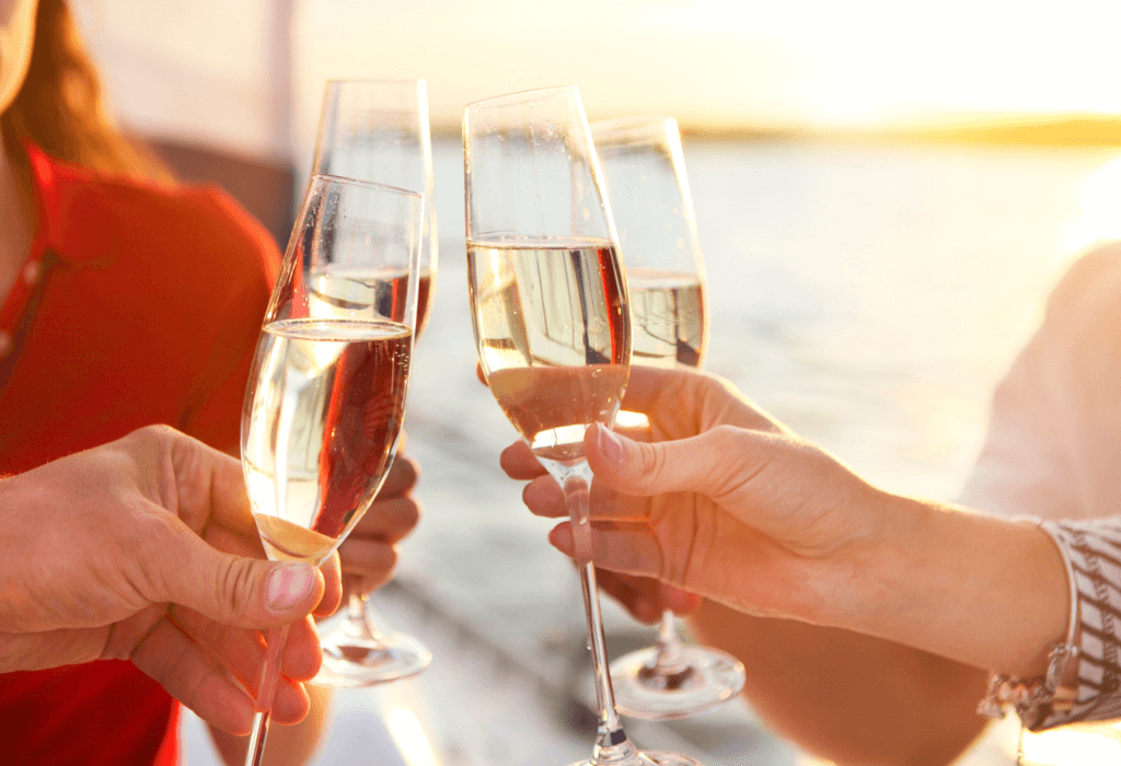 champagne toast on a boat at sunset for story on cruise deals 2024
