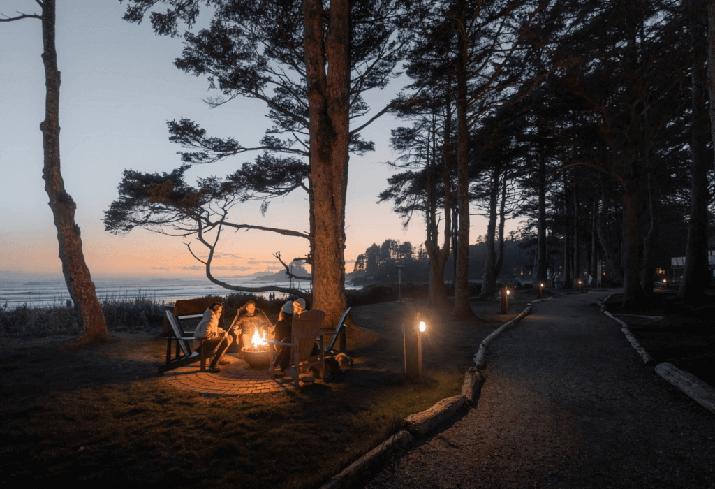 Guests relax by the firepit at sunset at Pacific Sands Resort in Tofino BC