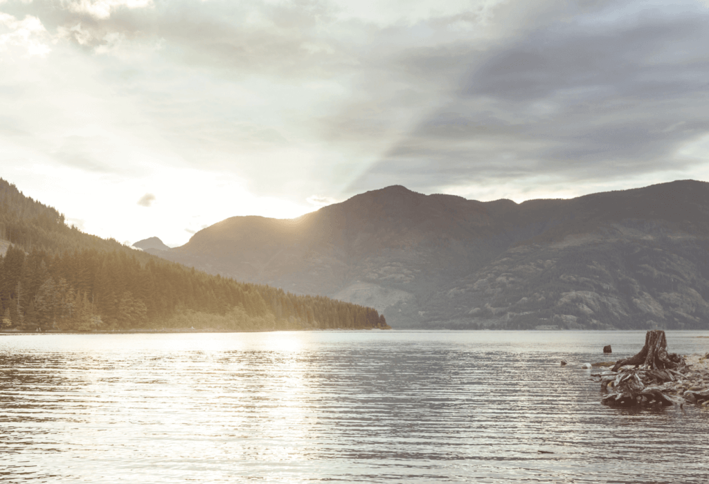 the sun's rays shining behind the mountains on Vancouver Island near Tofino BC