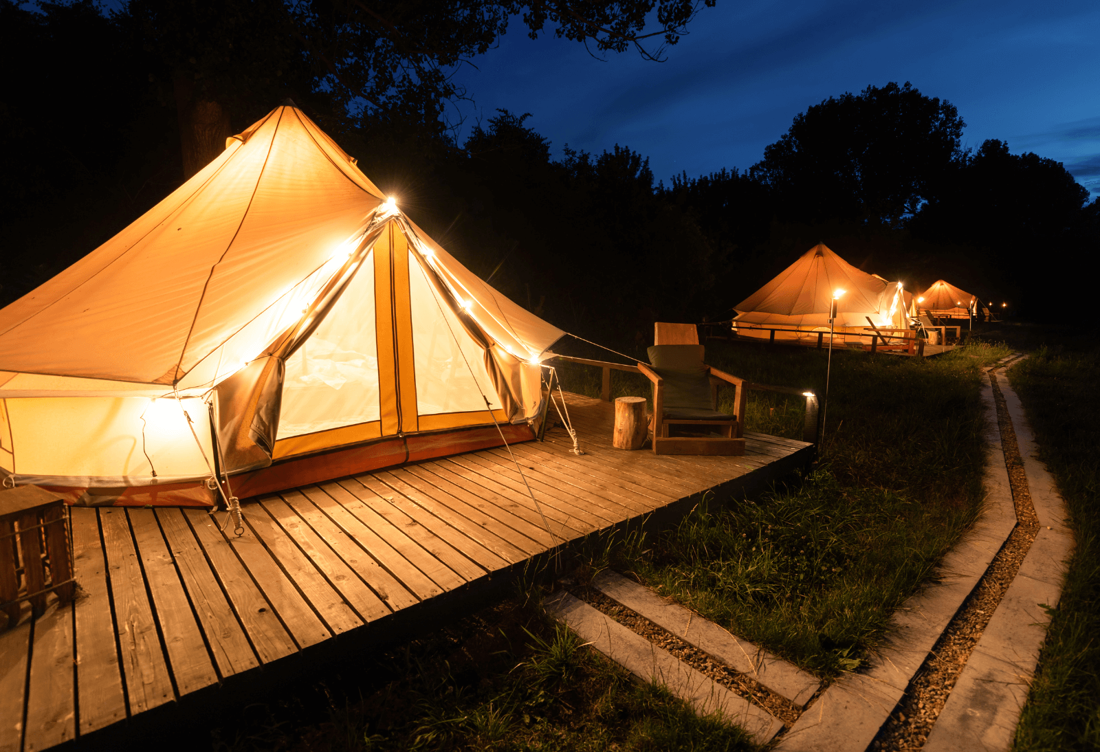 A group of glamping tents illuminated at nights