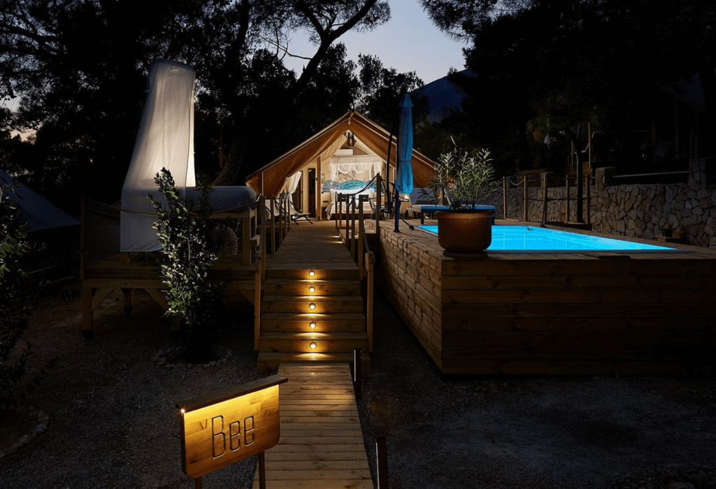 The outside of glamping tents in a Croation camping site with a pool