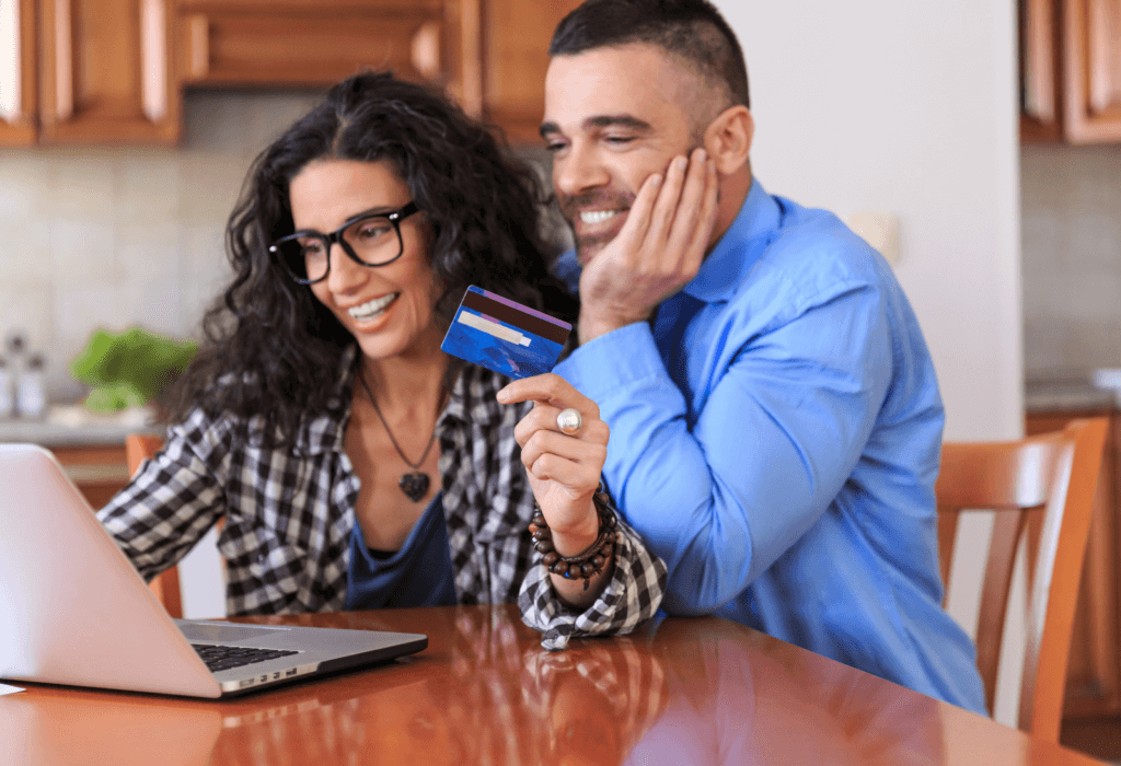 A couple booking travel online using their no annual fee credit card