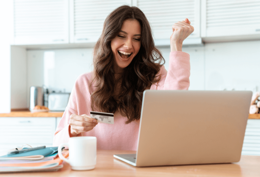 excited woman booking travel with her credit card